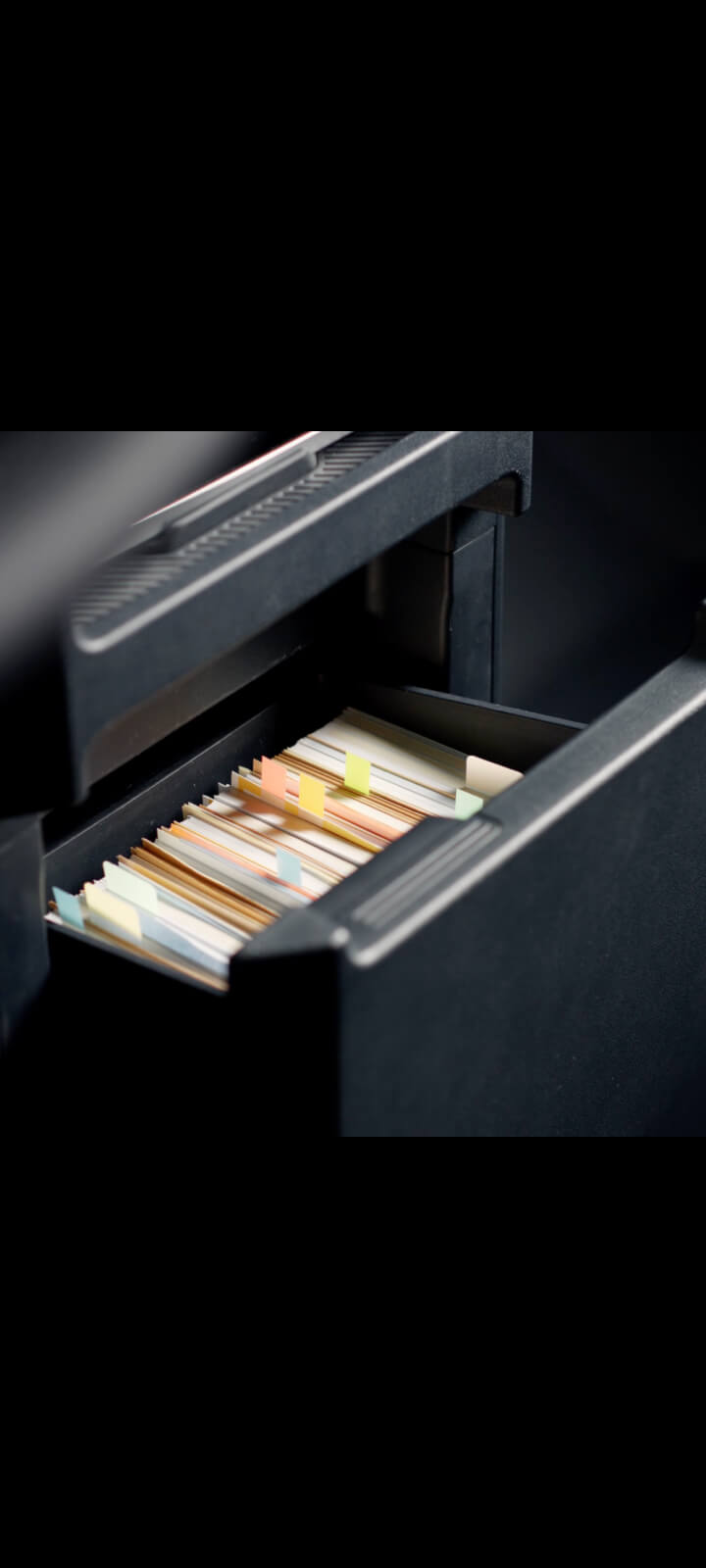 Schublade in der Mittelkonsole des Kia PV5 Passenger mit abgelegten Unterlagen.